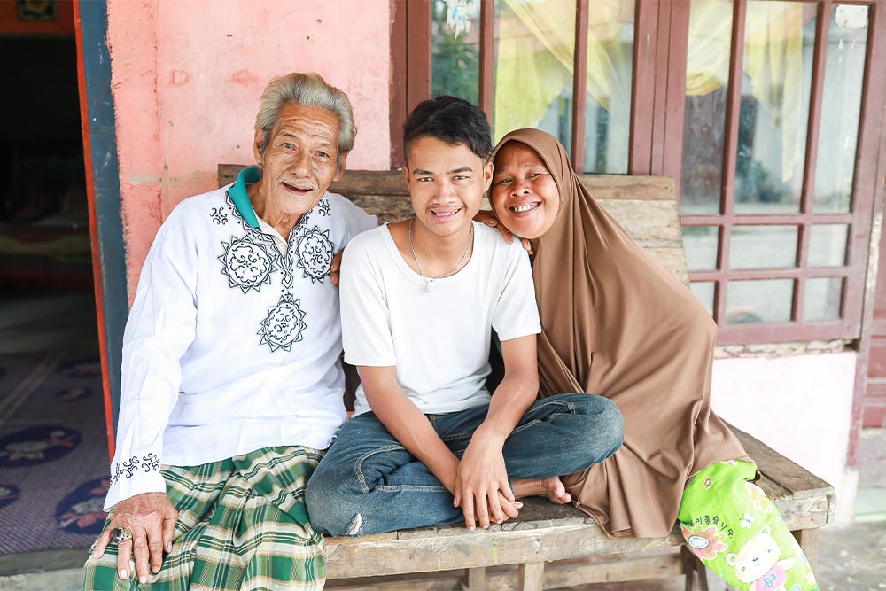 Angga smiling with his parents Aberil and Nurelela after his cleft surgery