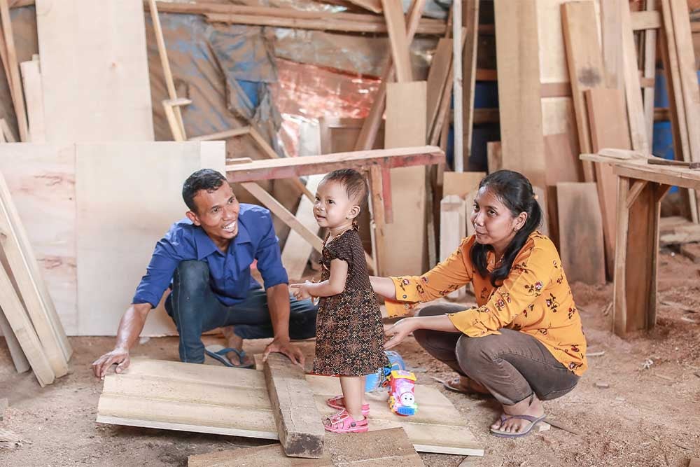 Yatna and Mawar smiling and playing with Siti after her cleft surgery