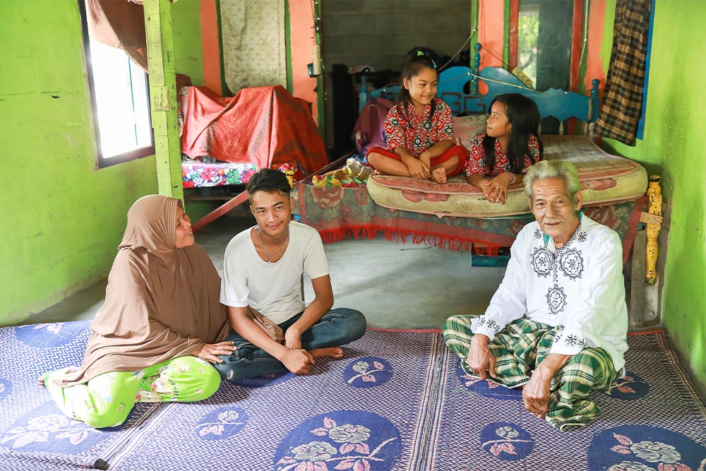 Angga sitting with his family after his cleft surgery