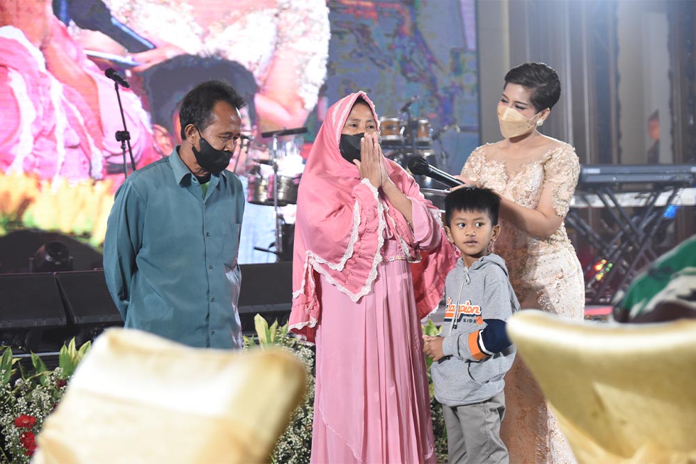 Achri mewawancarai keluarga pasien Smile Train Indonesia ke-100.000 di atas panggung