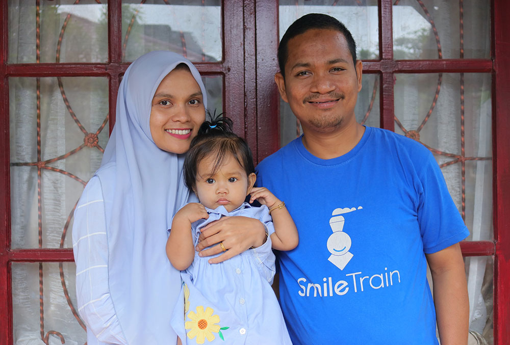 Rahman tersenyum bersama istrinya Novy dan putrinya Phoenna