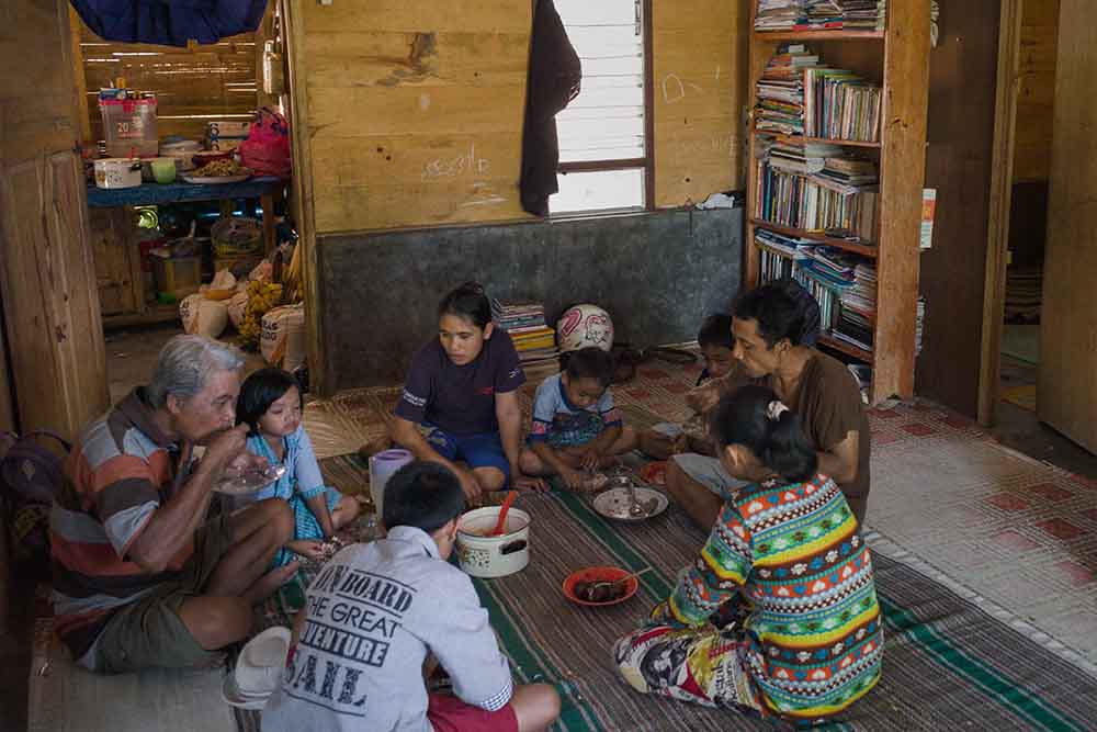 Natsir eating with his family on the floor
