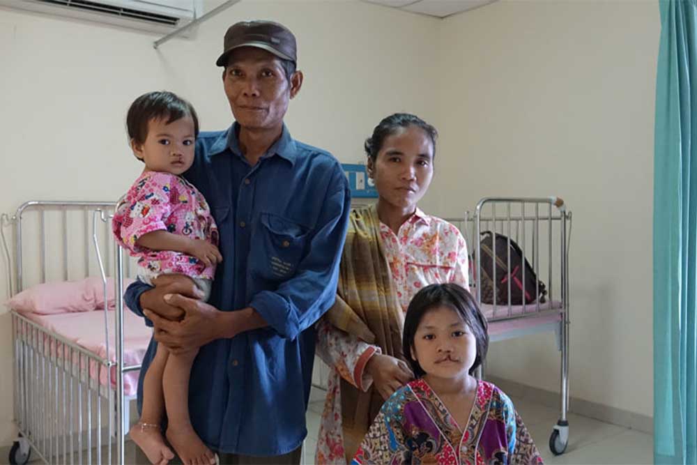 Smile Train patients Aura and Aulia smiling with their parents before cleft surgery