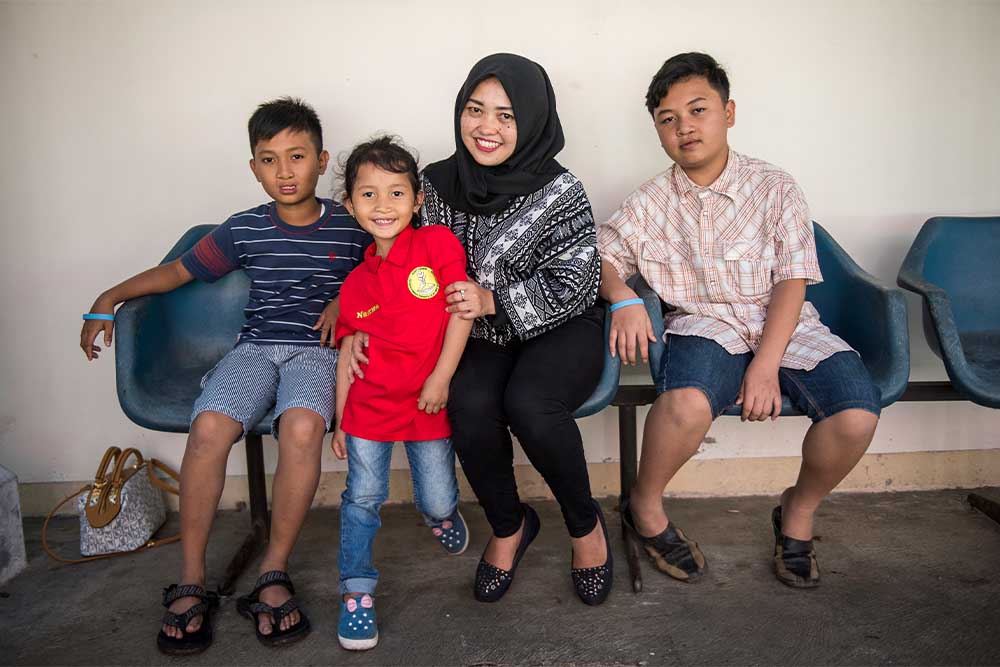 Siti smiling with Levi, Wanqsa and Nazwa after their cleft surgeries