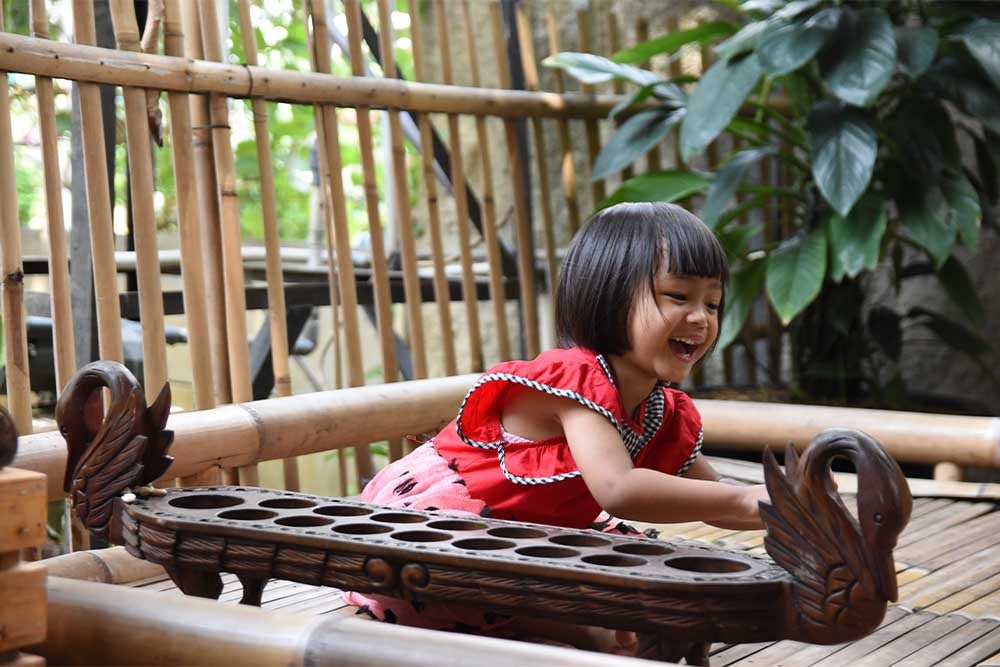 Khalisa smiling and playing mancala