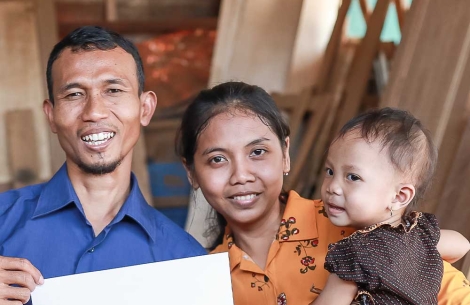 Yatna and Mawar smiling and holding Siti after her cleft surgery