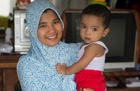 Emaiti smiling and holding Zawata after their cleft surgery