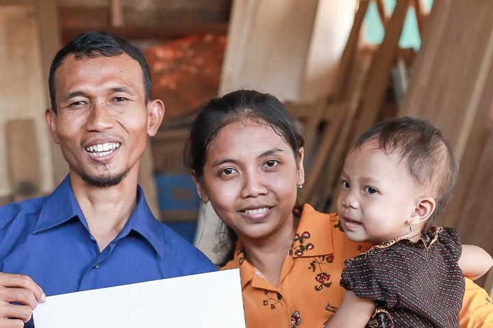 Yatna and Mawar smiling and holding Siti after her cleft surgery