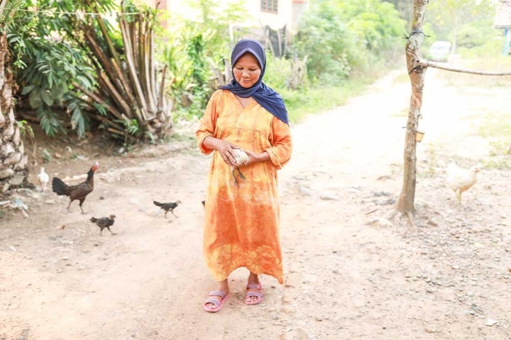 Jayem walking and holding a chicken after cleft surgery