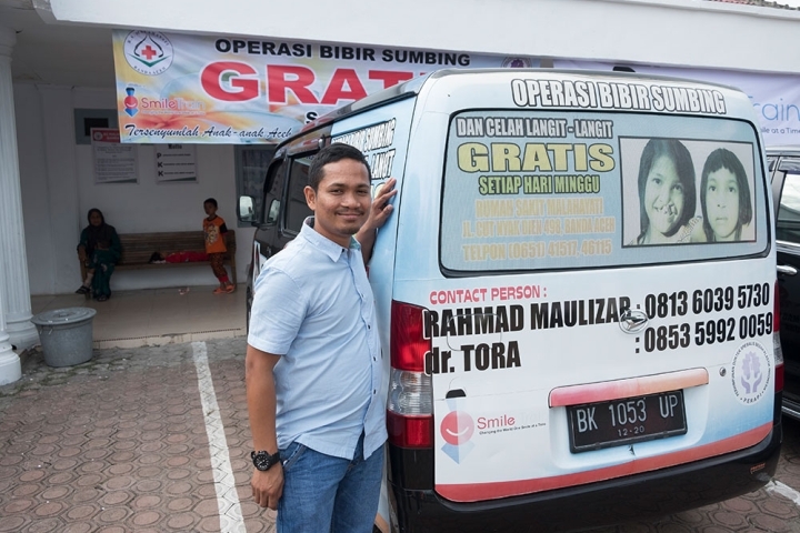 Rahmad smiling next to his van