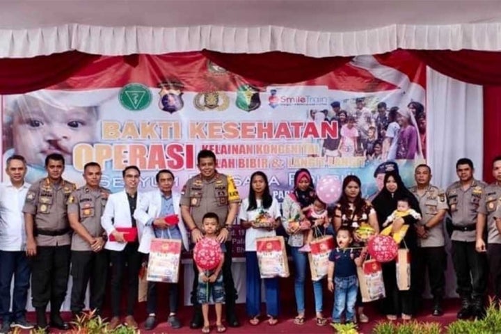 Indonesian police officers smiling with Smile Train patients and staff in Samarinda