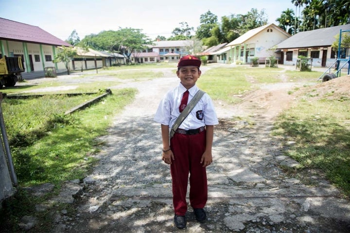 Deri tersenyum dan berdiri di luar sekolah setelah operasi sumbingnya