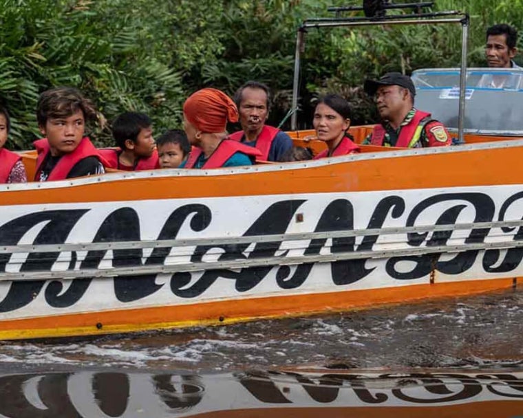 Alim dan Rajib menaiki perahu bersama keluarga mereka ke pusat perawatan sebelum operasi bibir sumbing
